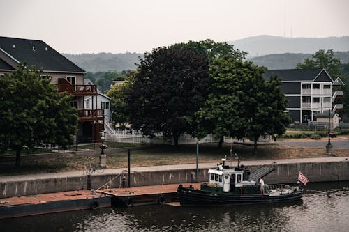 A Tugboat in the Canal in a Town 