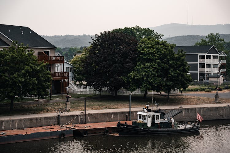 A Tugboat In The Canal In A Town 