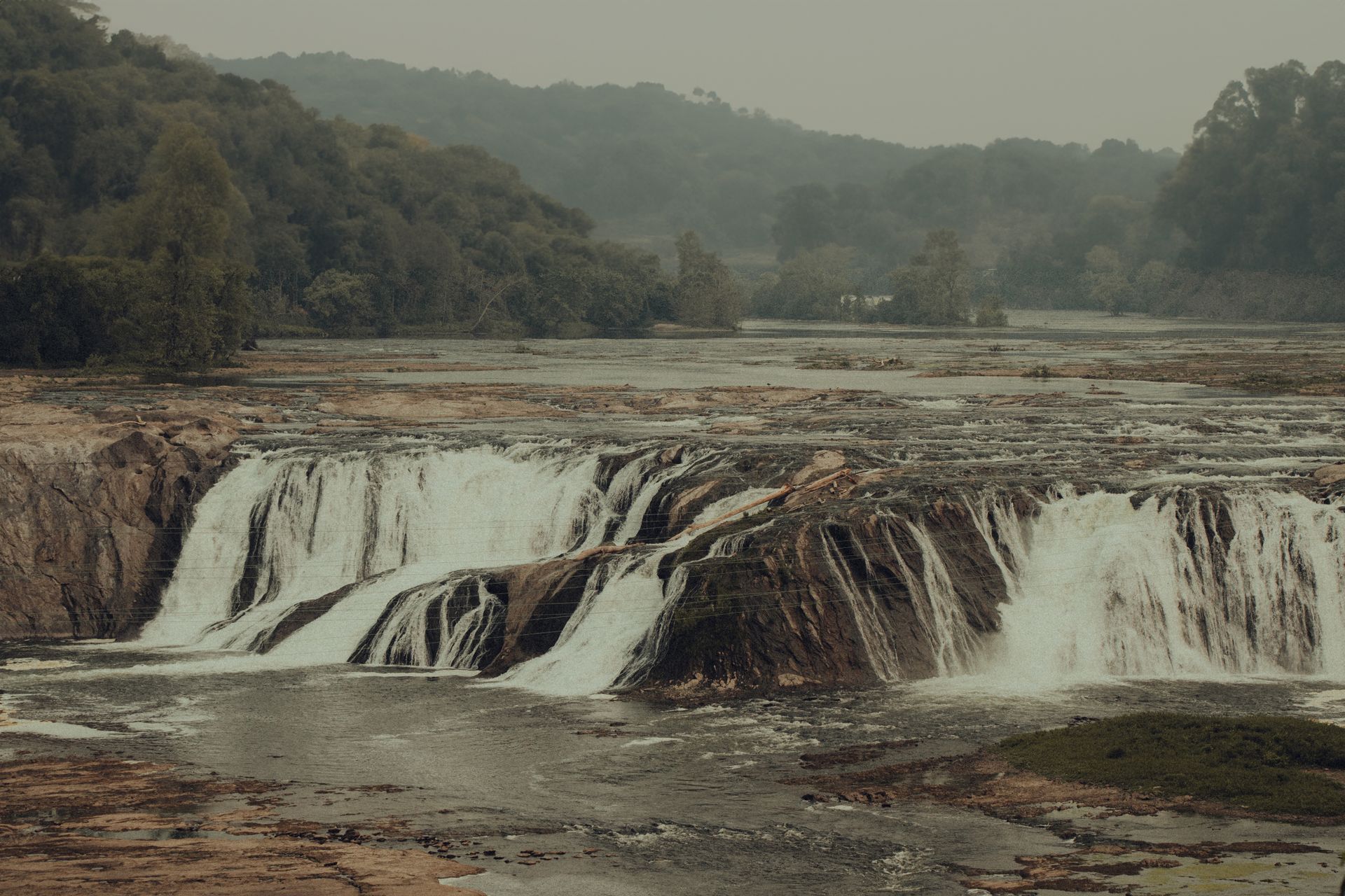 Majestic waterfalls cascade through a serene forest, offering a breathtaking view of nature's tranquility.