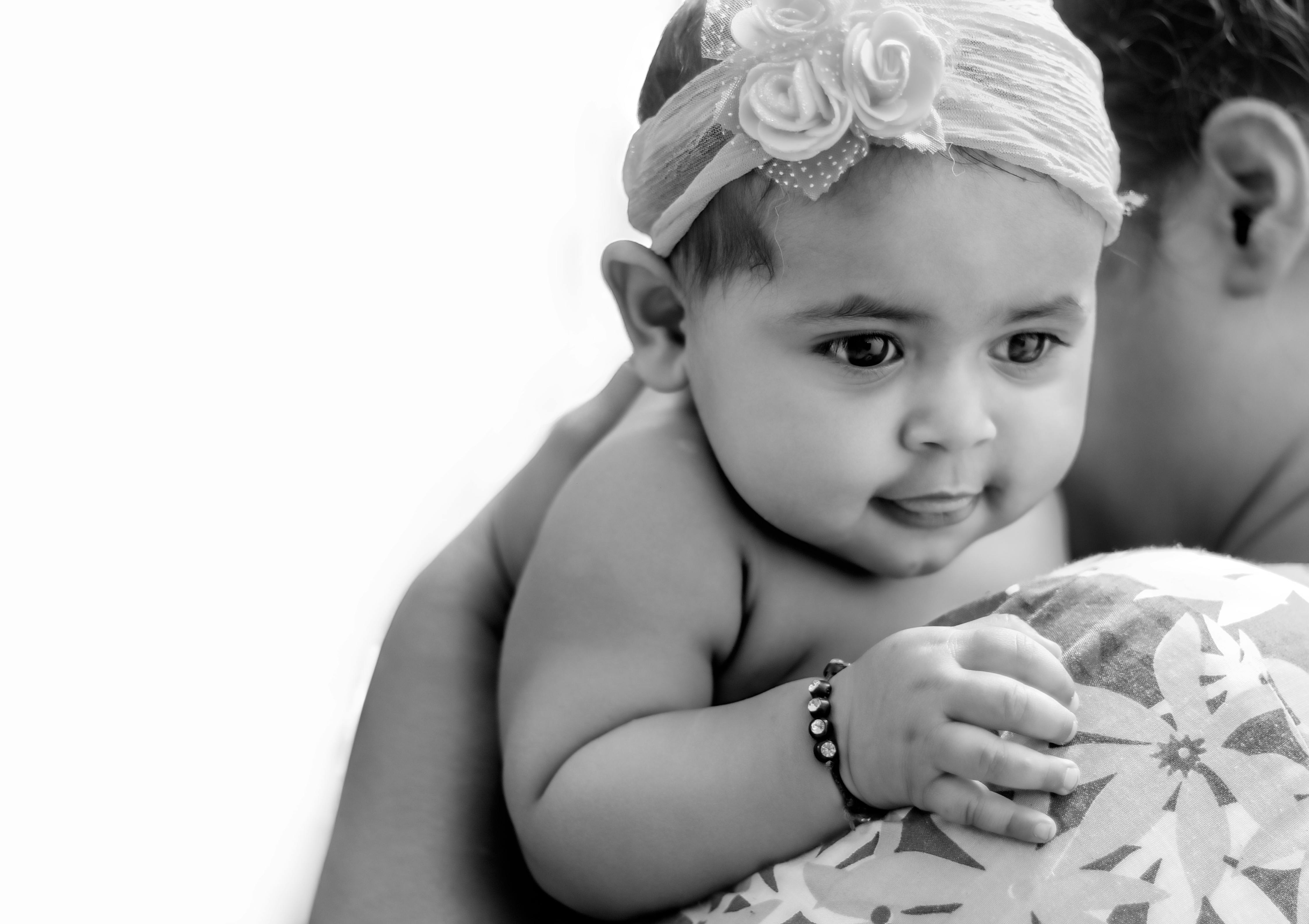 A heartwarming black and white portrait of a baby girl resting on her mother