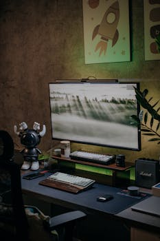 Cozy desktop setting with monitor, keyboard, and unique decorations in a home office.