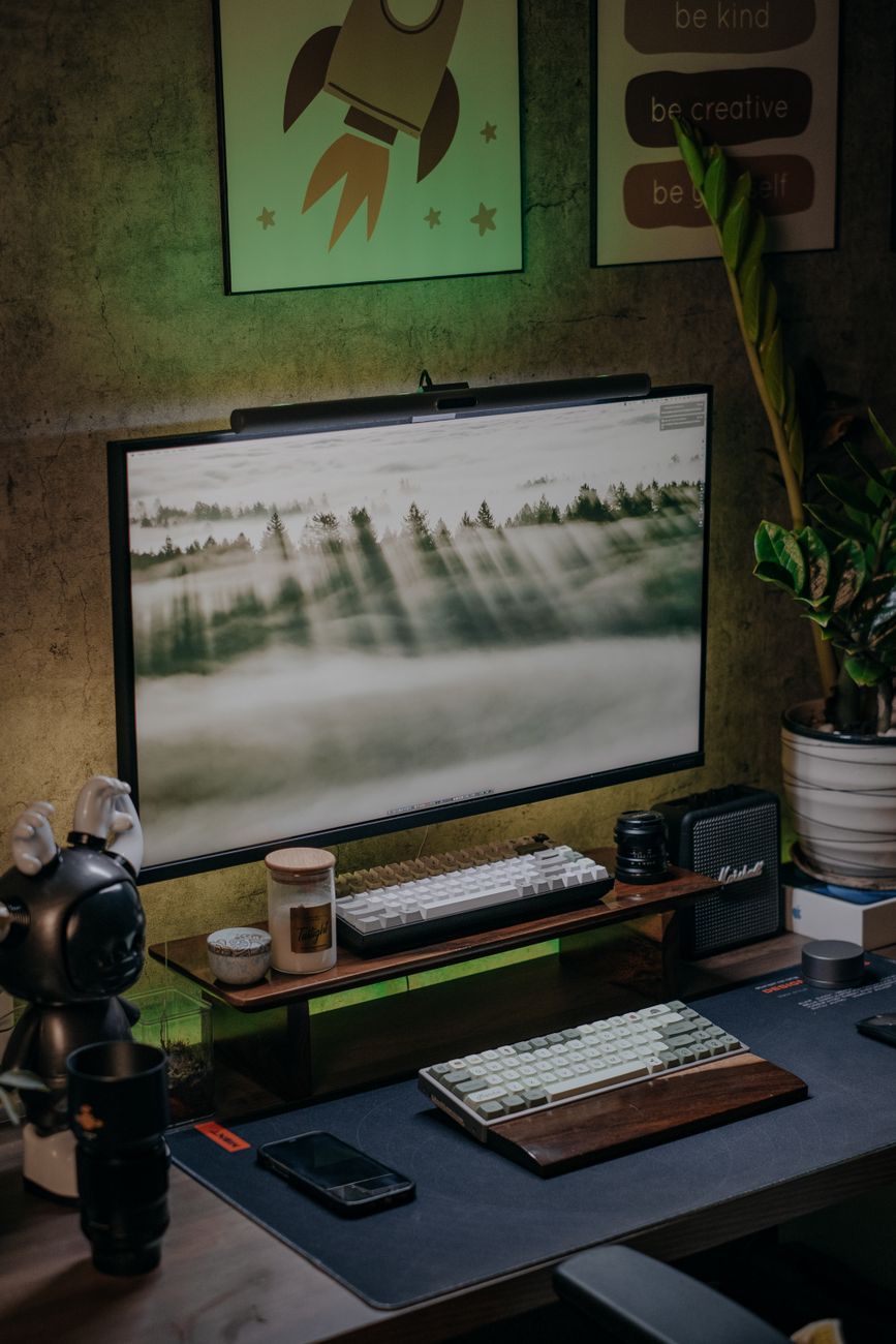 Stylish home office desk setup with monitor, keyboard, and decor. Ideal for productivity.