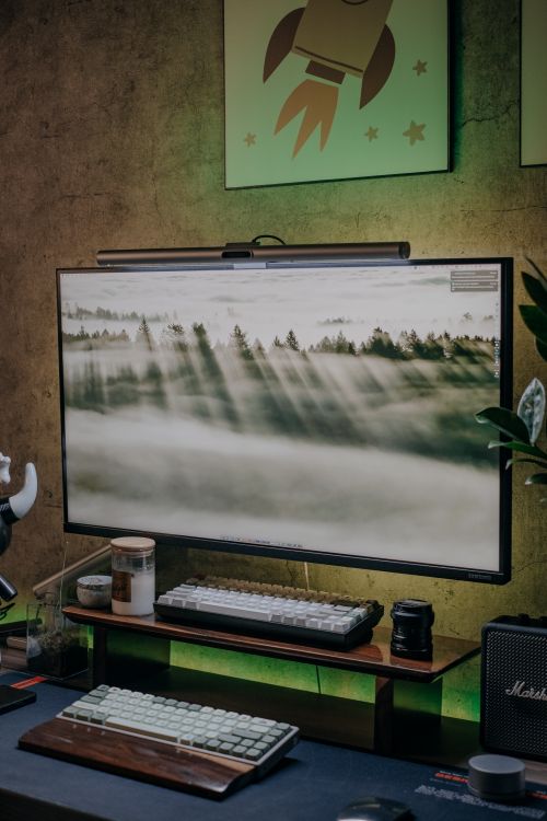 Free Stylish modern desk setup featuring a large monitor and keyboard in an ambient indoor environment. Stock Photo