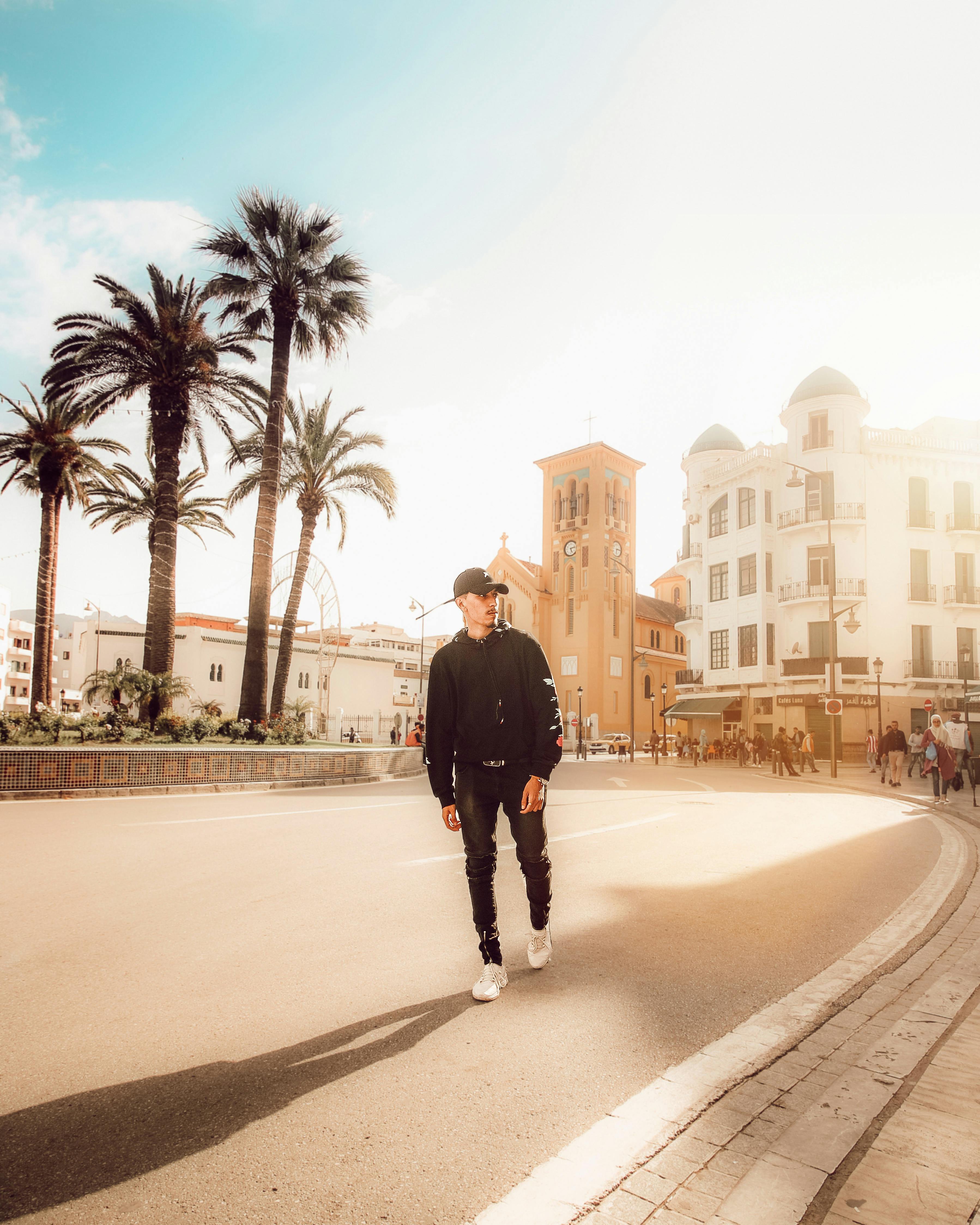 走在长满棕榈树和历史建筑的活力街道上，时尚的男人显得格外引人注目