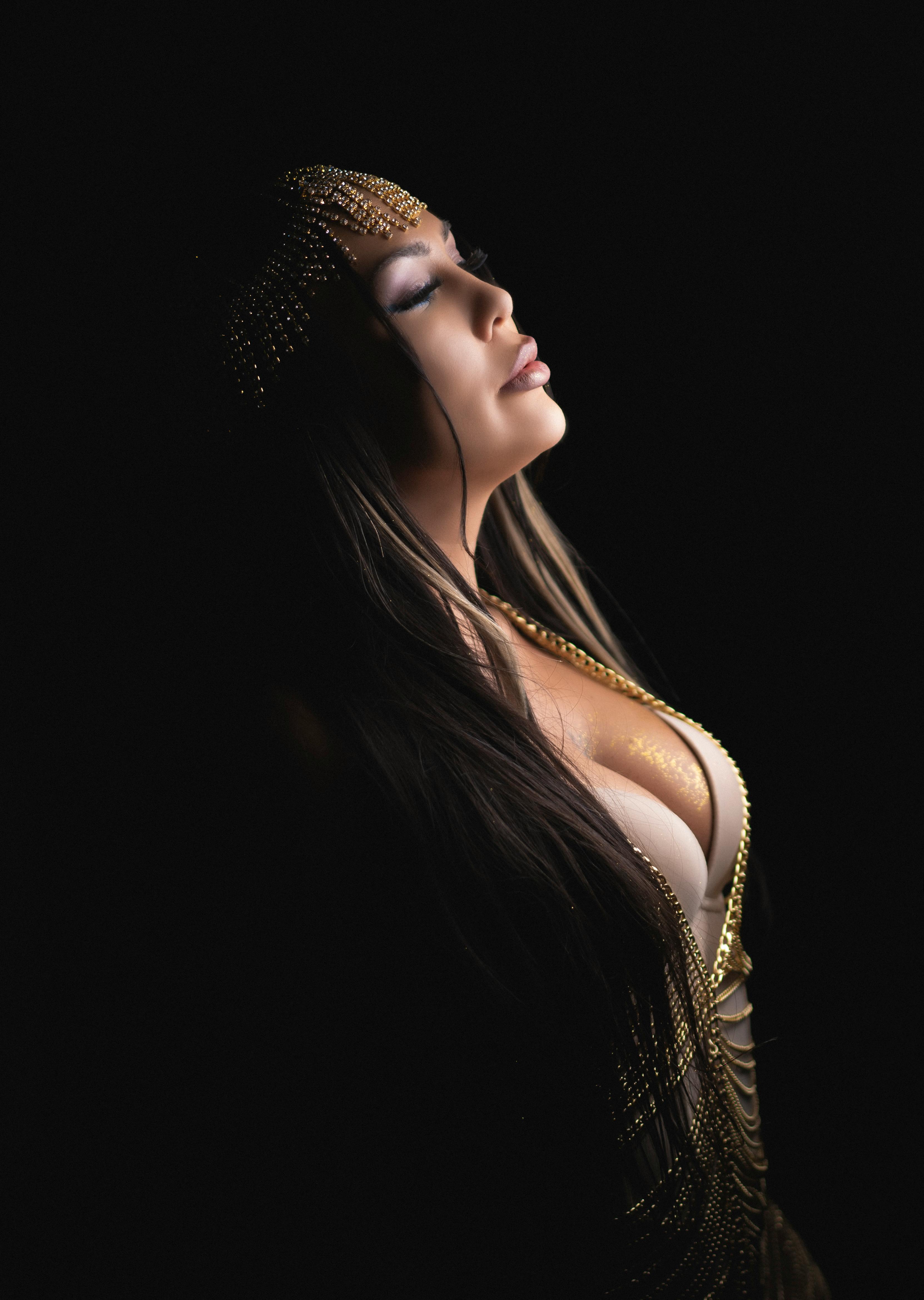Glamorous studio portrait of a woman in profile view, exuding elegance with dramatic lighting.