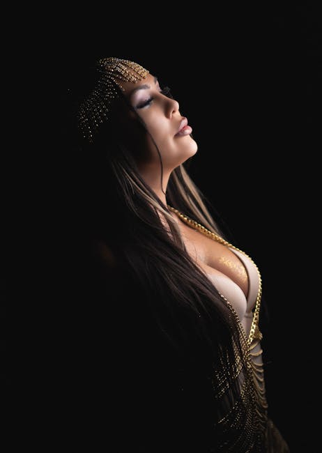 Glamorous studio portrait of a woman in profile view, exuding elegance with dramatic lighting.