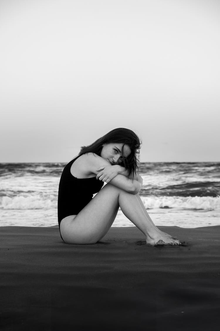 Black And White Picture Of A Young Woman In A Swimming Costume Sitting On The Beach 