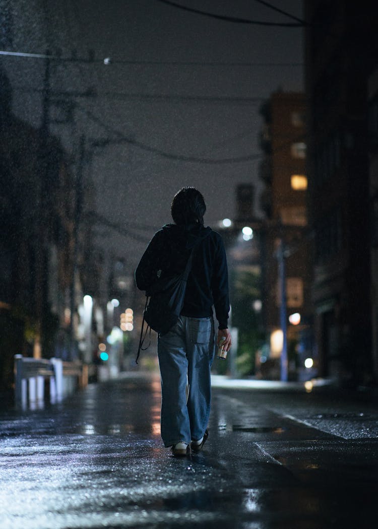 Woman Walking In City At Night