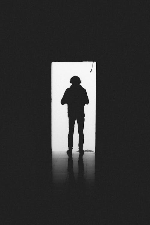 Silhouette of a Man Standing in the Doorway 