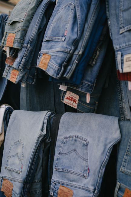 Folded and hanging jeans in a clothing store in Madrid, showcasing fashion variety.