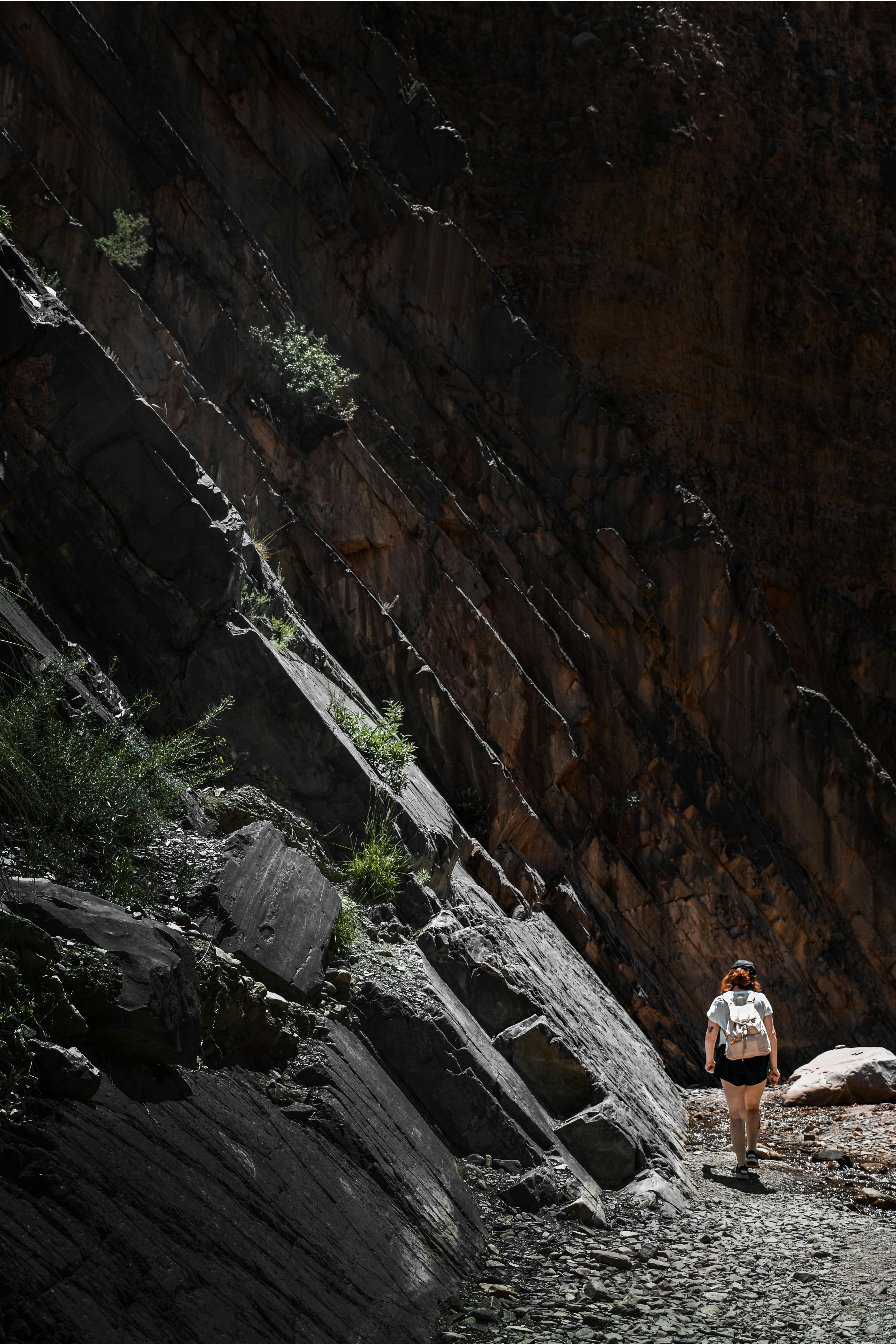 Woman Hiking near Barren Rocks · Free Stock Photo
