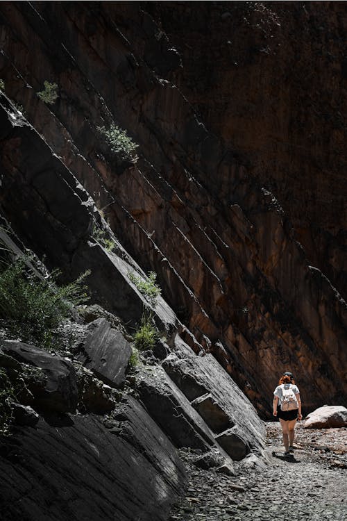 Woman Hiking near Barren Rocks