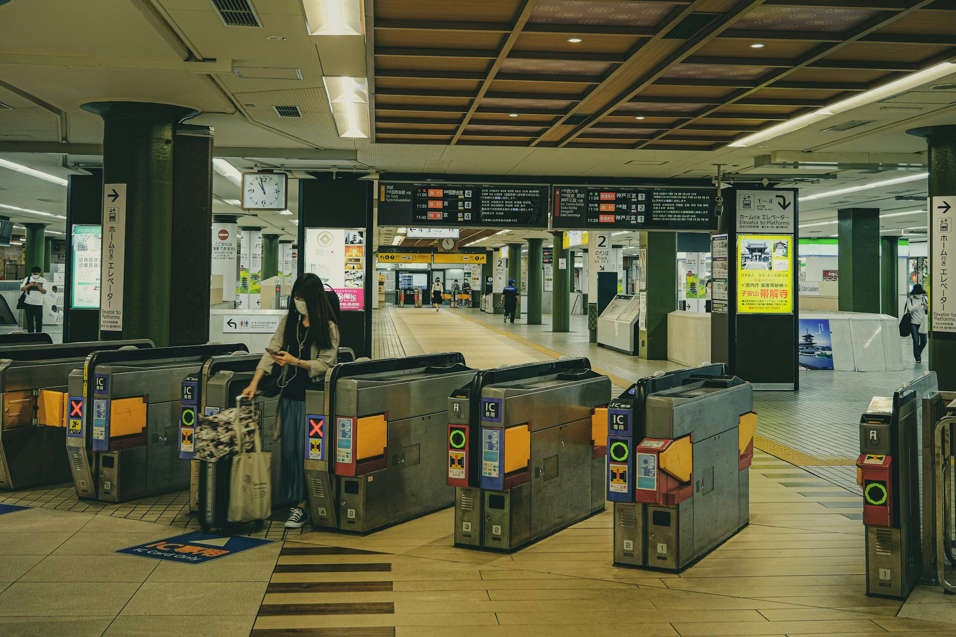 A Japanese railway station in Nara featuring ticket gates and travelers, illustrating urban transit life.