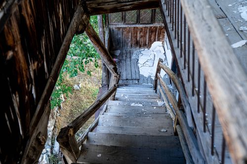 Free An old wooden staircase in a dilapidated house with peeling paint and debris. Stock Photo