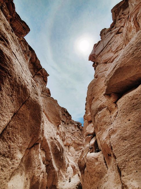 Vertical shot of a stunning sandstone canyon with eroded rock formations under a clear blue sky.