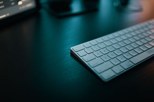 Sleek white keyboard on a dark desk, ideal for modern workspace themes.
