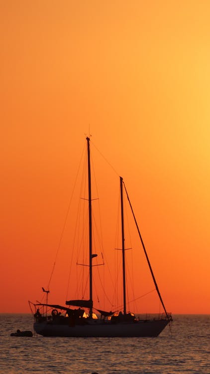 Silhouetted Sailboat on the Background of Orange Sky 