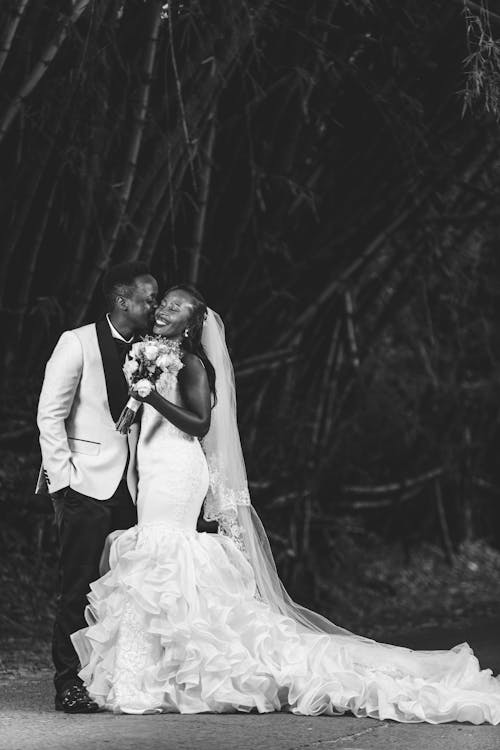 Black and White Photo of Groom Kissing Happy Bride