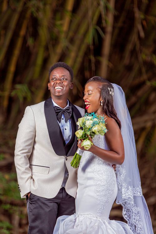 Free Happy bride and groom laughing together in beautiful outdoor setting. Stock Photo