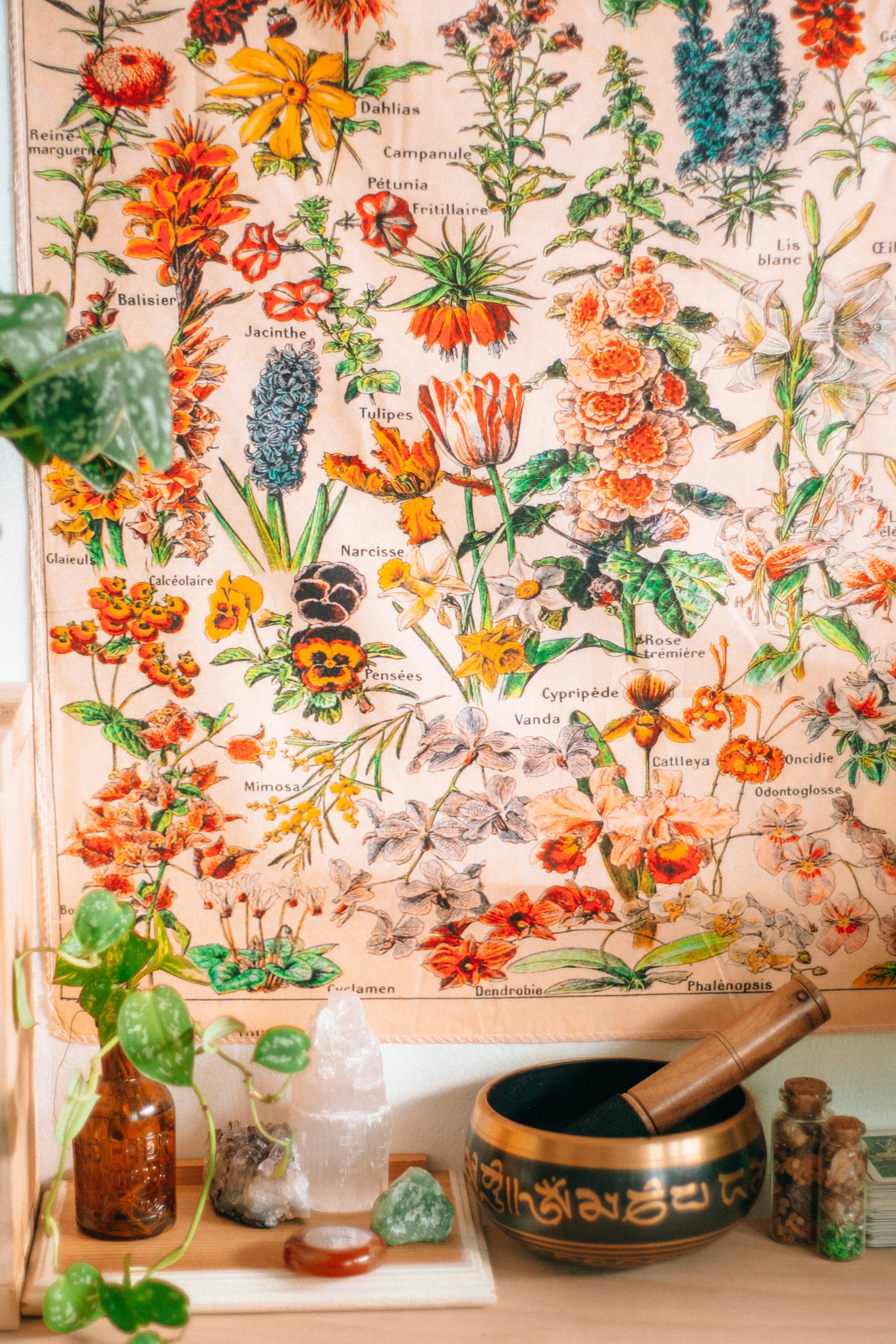 A vintage botanical poster featuring vibrant flowers, complemented by healing crystals and a sound bowl.