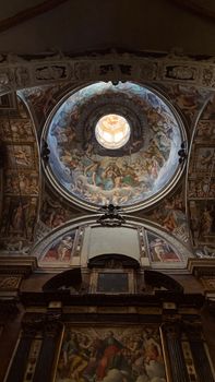 A detailed fresco decorates the dome of a historic church interior.