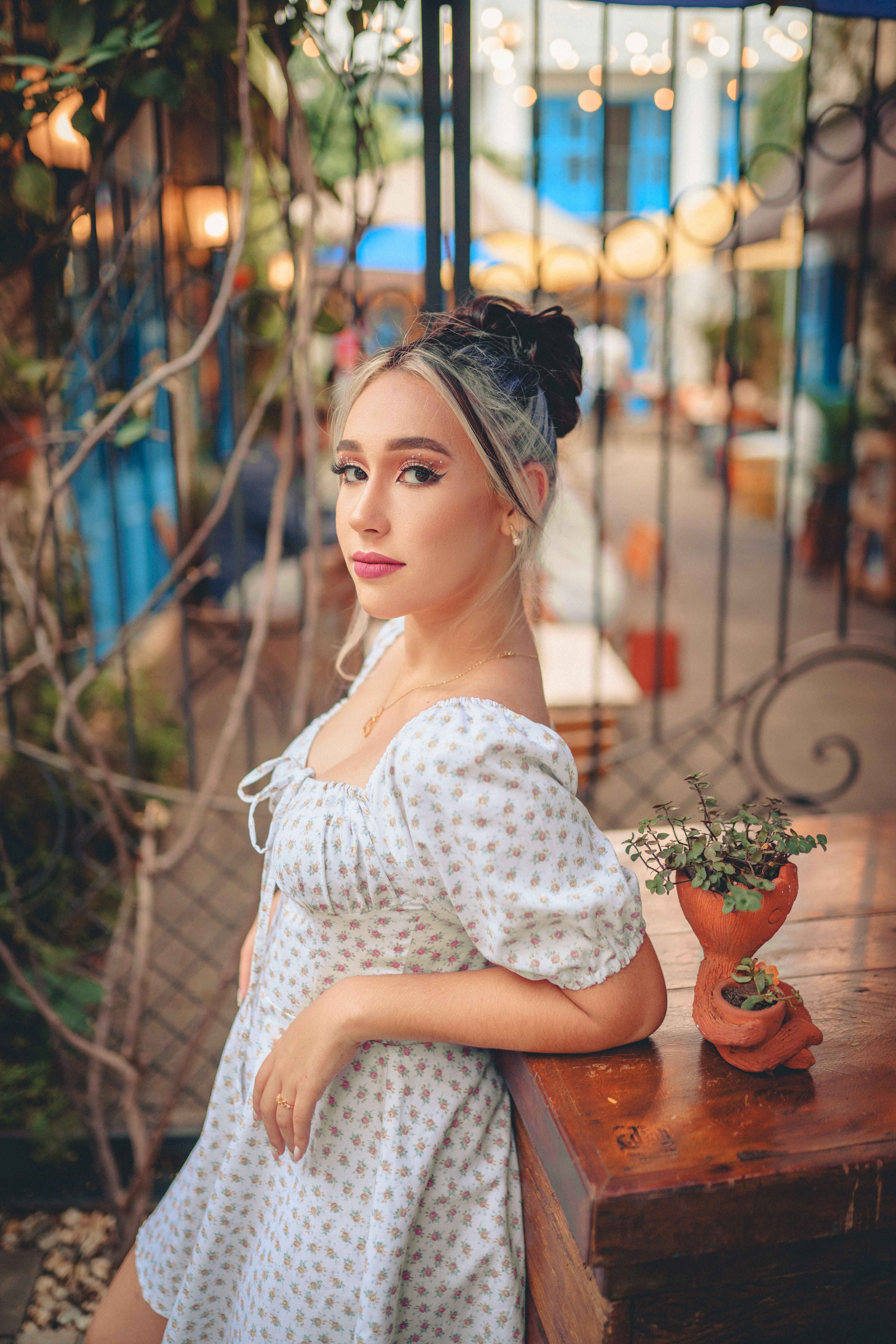 Young Woman in a Summer Dress Standing by the Table on the Patio  Free  Stock Photo