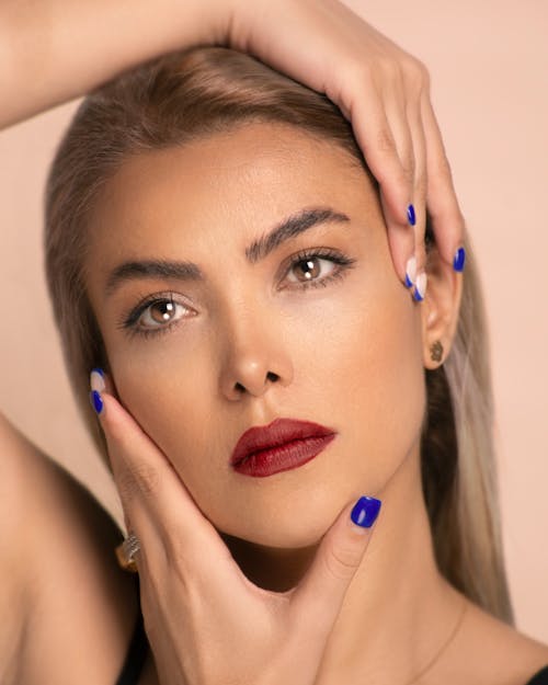 Portrait of Woman with Blue Nails Holding her Face