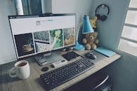 整洁的家庭办公桌上配备着电脑、键盘和个人用品，营造出舒适的工作氛围