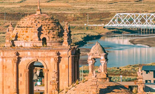 Free Majestic ancient temple with bridge over a tranquil river in a rustic landscape. Stock Photo