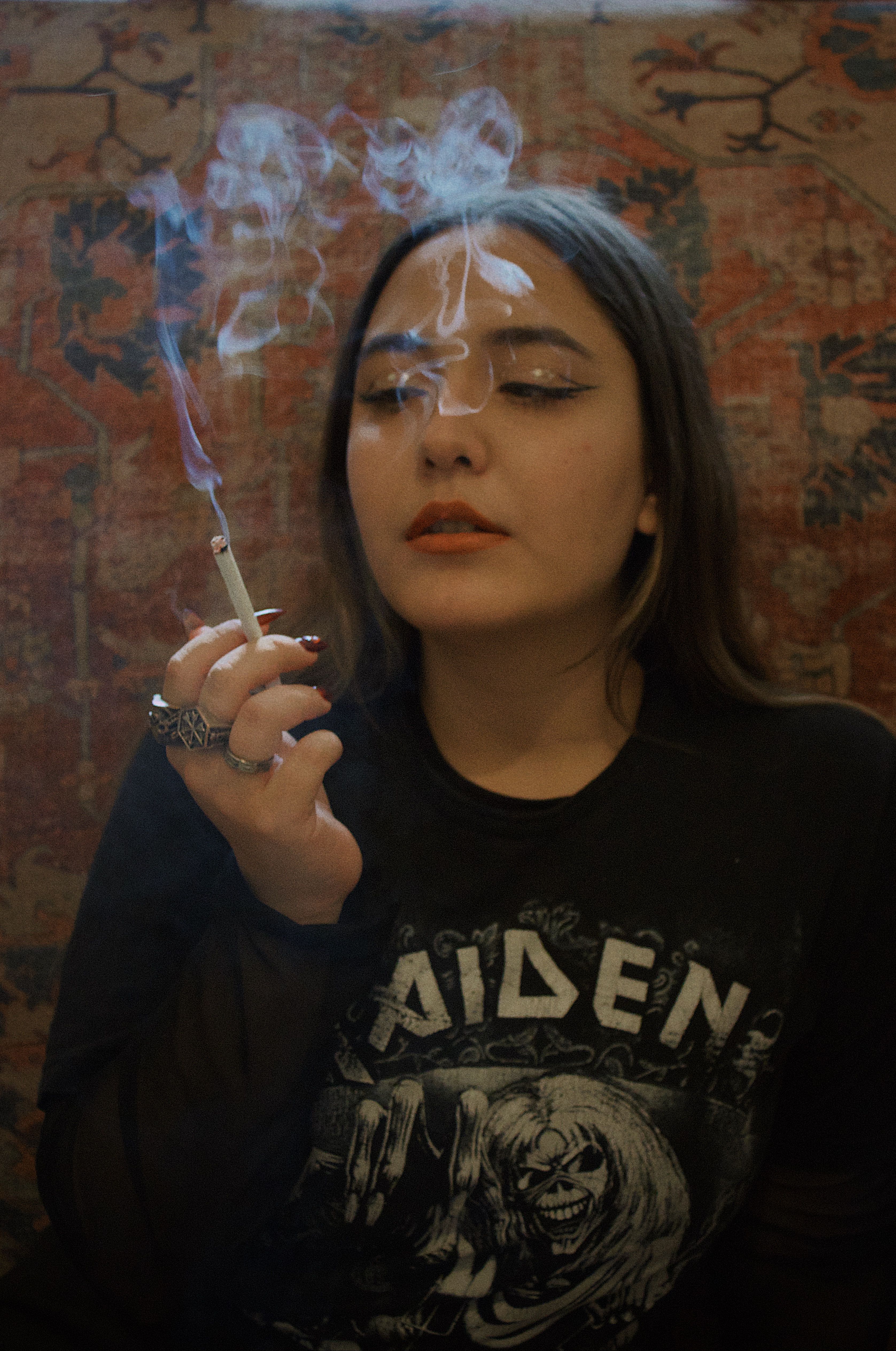 cigarette in room A woman smoking a cigarette in a room · Free Stock Photo