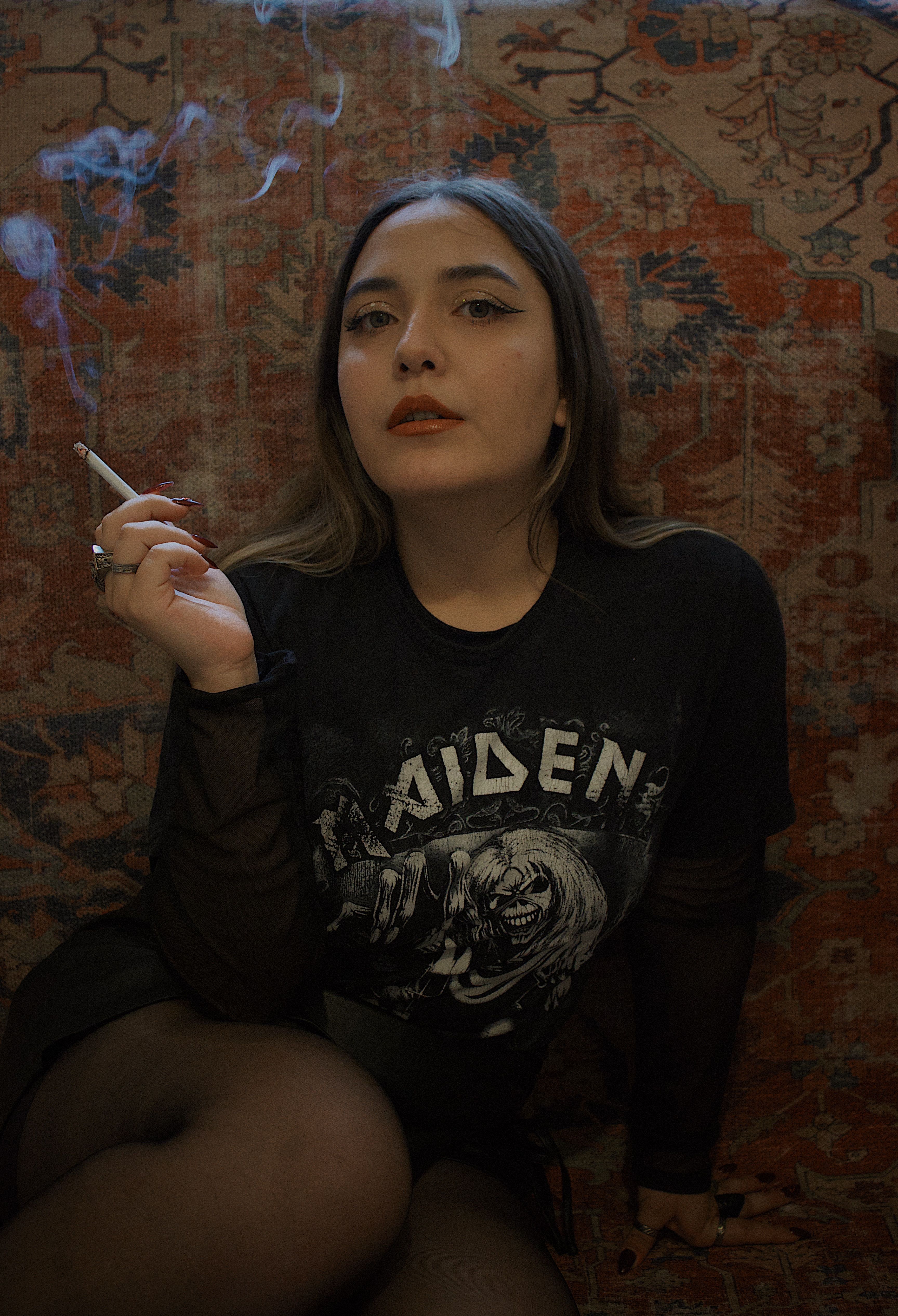 A woman smoking a cigarette on a couch · Free Stock Photo