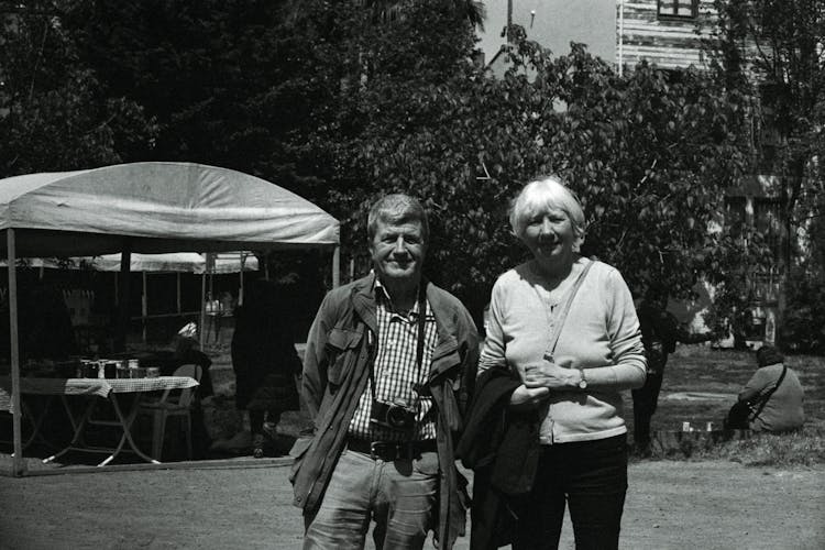 An Old Black And White Photo Of Two People Standing In Front Of Tents