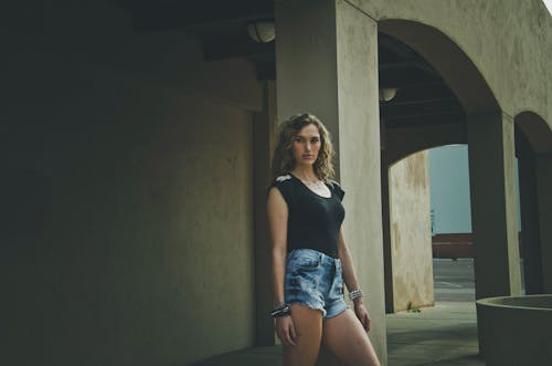 Brunette Woman in Denim Shorts Posing by Column