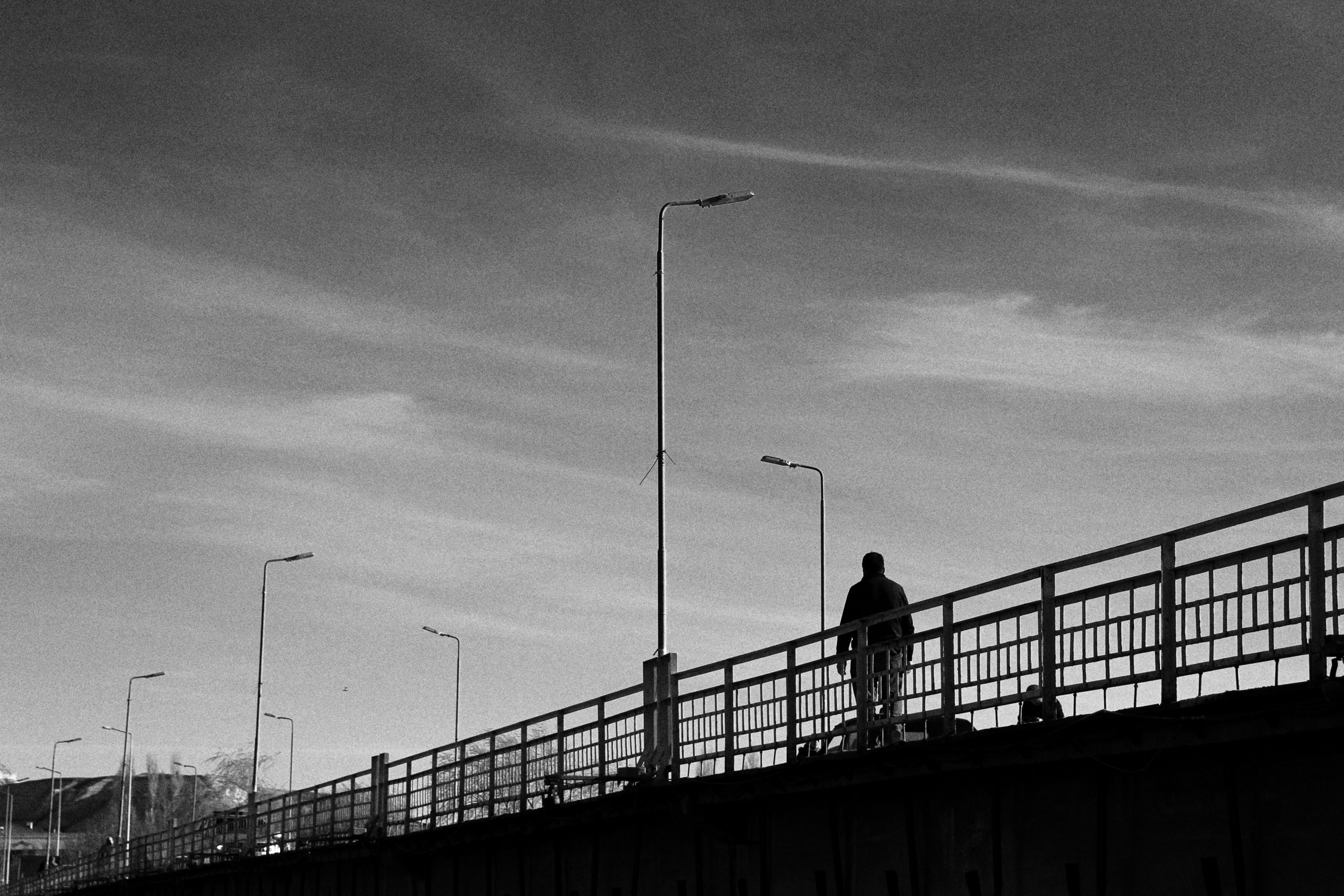 Silhouette of Person Walking on Bridge · Free Stock Photo