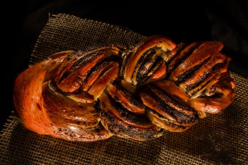 Free A close-up top view of freshly baked braided bread with nut and poppy seeds on burlap. Stock Photo