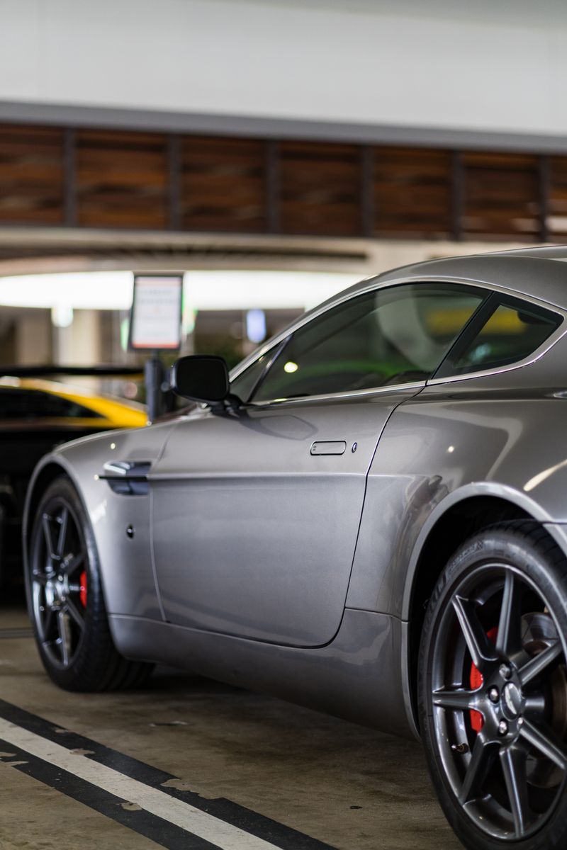 Close-up of a silver sports car parked indoors, showcasing modern design and luxury.