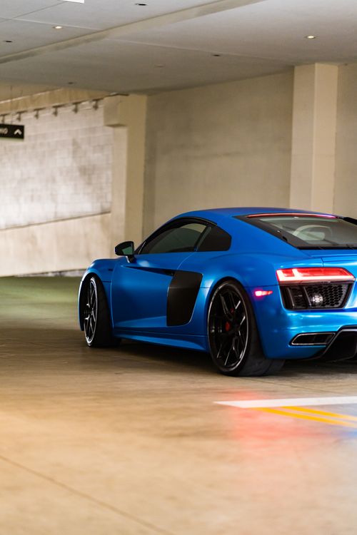 Free Dynamic rear view of a blue supercar parked in an indoor garage, showcasing sleek design. Stock Photo