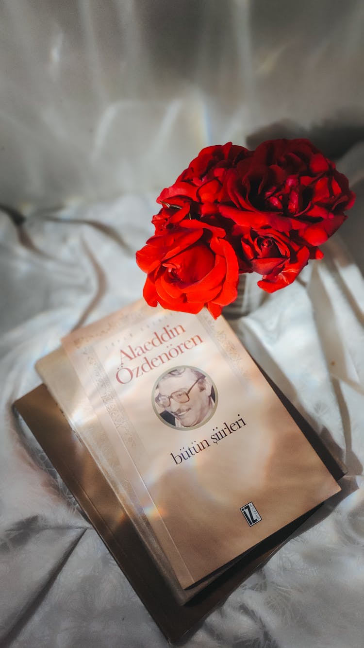 Poetry Book Of Alaeddin Ozdenoren And Red Roses Lying On A Bed