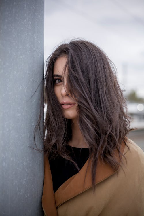 Young Woman Posing near Grey Wall