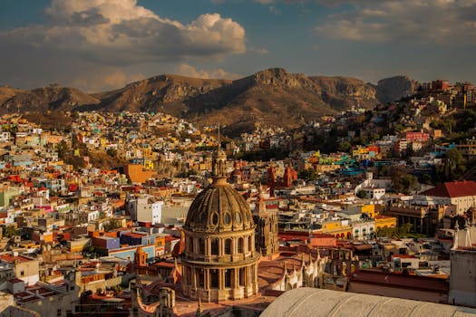 A vibrant aerial view of Guanajuato City showcasing colorful architecture and mountainous backdrop.