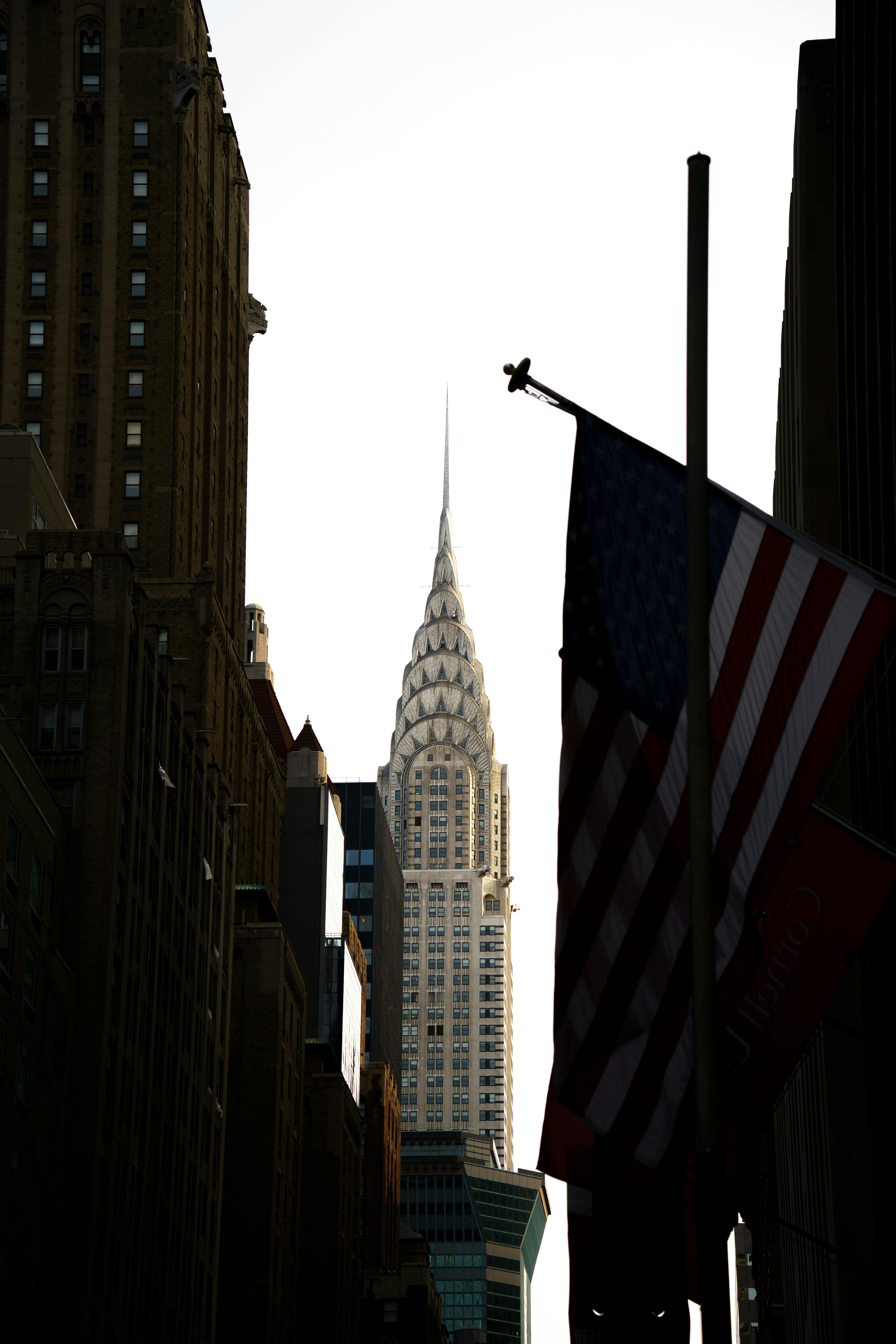 chrysler building behind flag of usa in new york