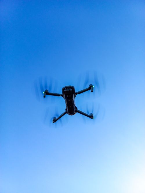 Free Aerial shot of a drone flying against a clear blue sky, showcasing modern technology. Stock Photo