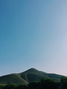 Serene landscape of a lush green mountain under a clear blue sky in Ixmiquilpan, Mexico.