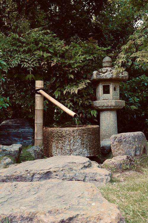 Free Peaceful Japanese garden featuring a stone lantern and traditional tsukubai water feature. Stock Photo