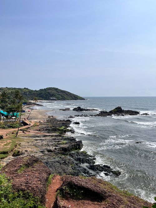 Free A peaceful rocky beach with clear blue skies and gentle waves, perfect for a summer getaway. Stock Photo