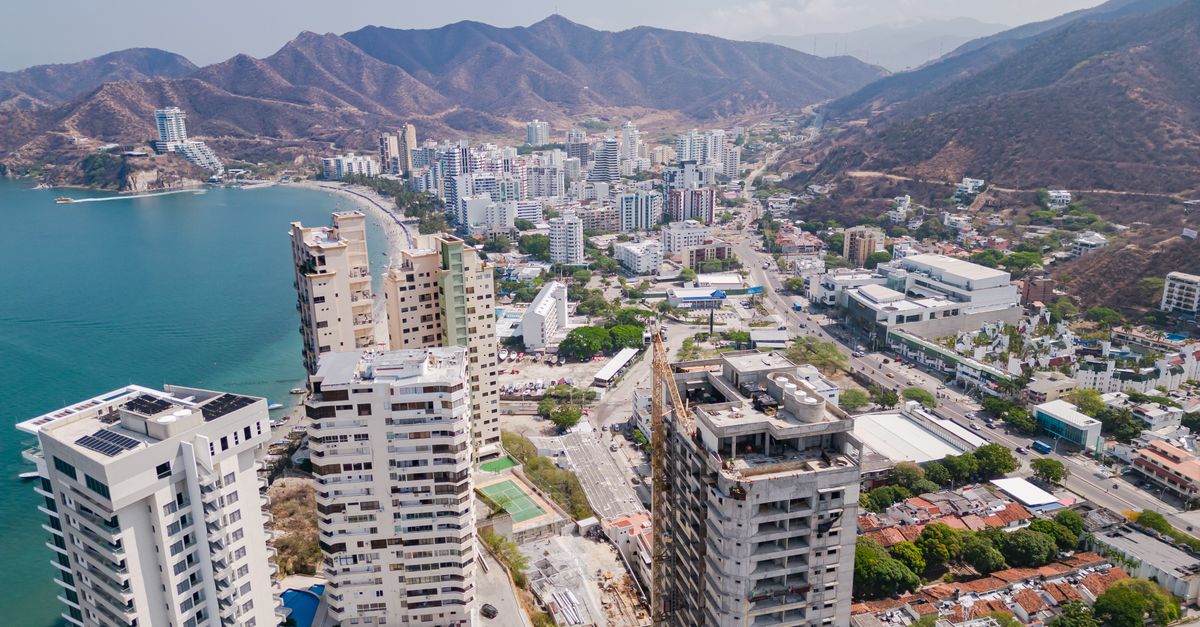 Drone shot of Santa Marta, Colombia showcasing urban skyline, coastline, and surrounding hills.