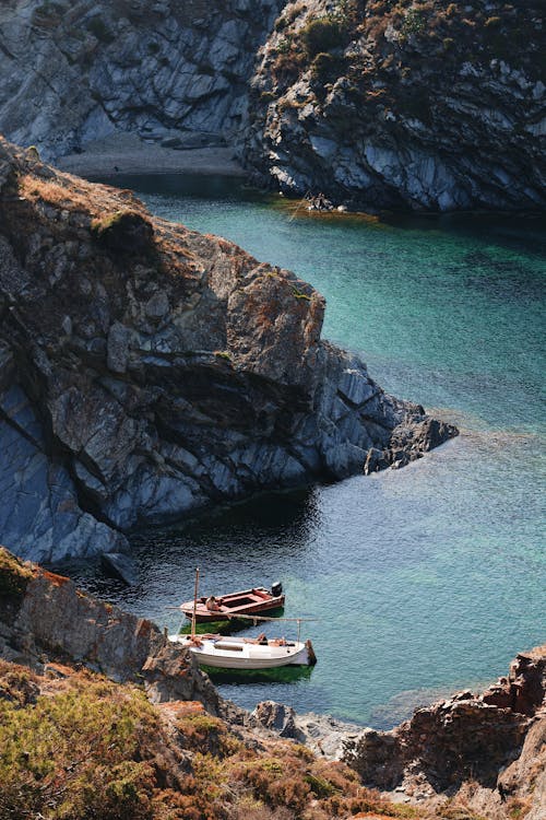 A boat is docked in the water near a cliff