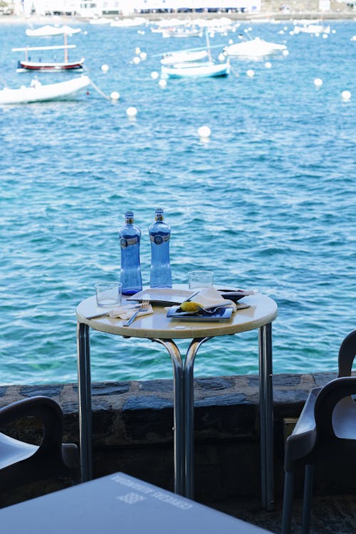 A table with two bottles of water and a view of the ocean