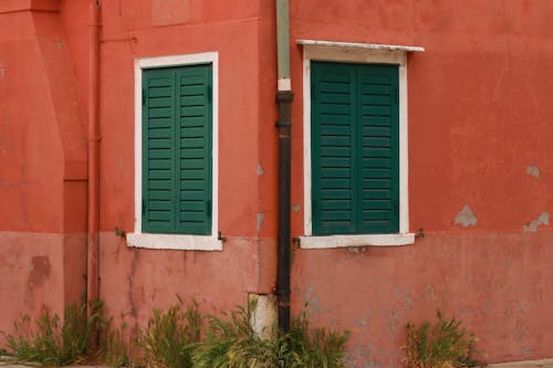 Gutter and Windows with Shutters in Building Corner