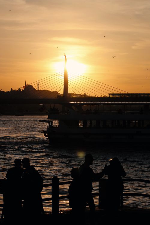 Free Silhouette of a ferry and people at sunset over İstanbul's Golden Horn bridge. Stock Photo